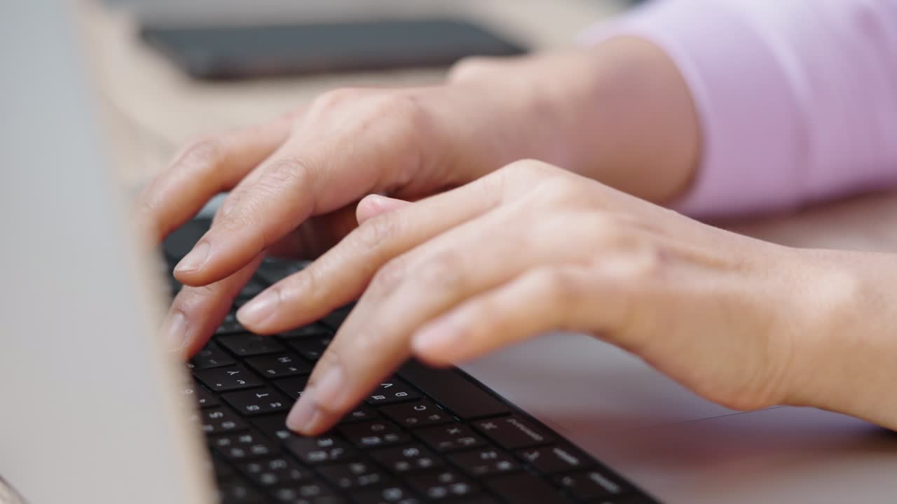 mano de cerca de una mujer de negocios escribiendo teclado computadora portátil en la oficina de escritorio