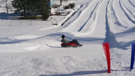 slow motion shot of a ski resort, man sledding on the snowy track