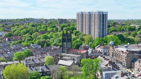 Der-Hohe-Kirchturm-Steht-Mitten-In-Einem-Wohngebiet-Zwischen-Den-Grünen-Bäumen-In-Newcastle,-Mit-Drei-Hochmodernen-Wohntürmen-Im-Hintergrund-An-Einem-Sonnigen-Tag