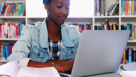 Niña-De-La-Escuela-Usando-Una-Computadora-Portátil-En-La-Biblioteca