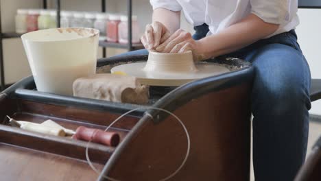 hands of a potter, creating an earthen jar on the circle