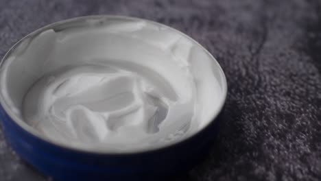 close-up of a blue jar with white cream inside