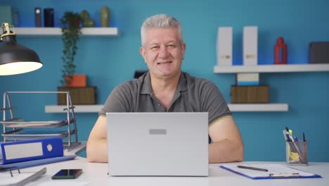 home office worker man smiles at camera.