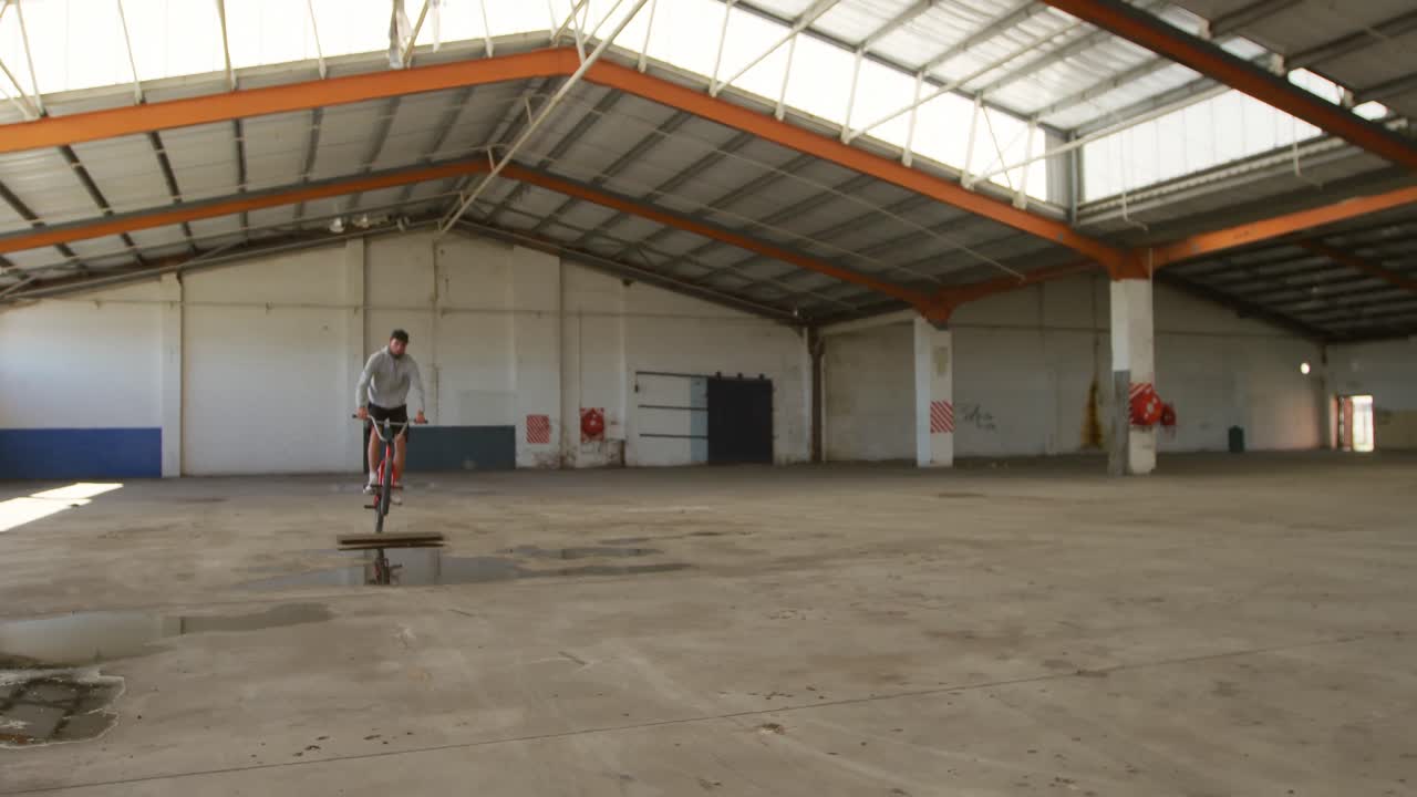 BMX rider in an empty warehouse
