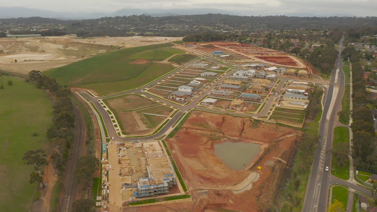 la cámara se mueve suavemente hacia adelante desde una perspectiva aérea, revelando un desarrollo de viviendas en progreso