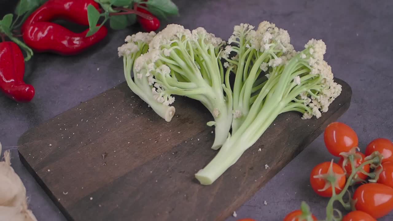 Cimette fresche di broccolo romanesco su un tagliere di legno