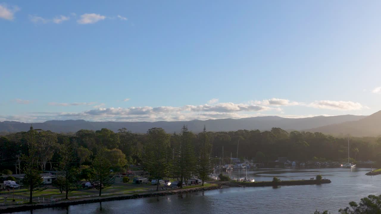 A serene sunset view over Brunswick Heads river, capturing calm waters, lush greenery, and a tranquil atmosphere
