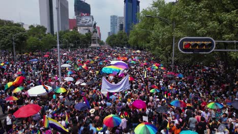 vibrant pride parade with a large crowd and rainbow umbrellas in a city