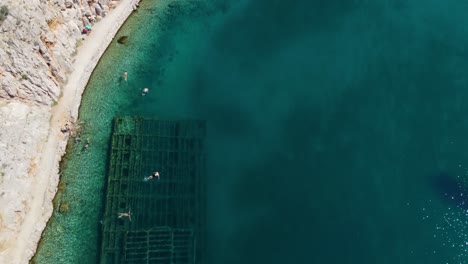 Aerial-birds-eye-flight-over-historic-sunken-shipwreck-ín-bay-of-Zavratnica-near-Jablanac-with-clear-view-from-above