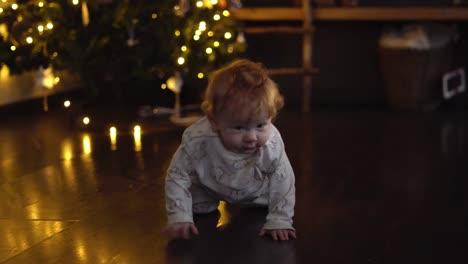 niña gateando frente al árbol de navidad en la sala de estar