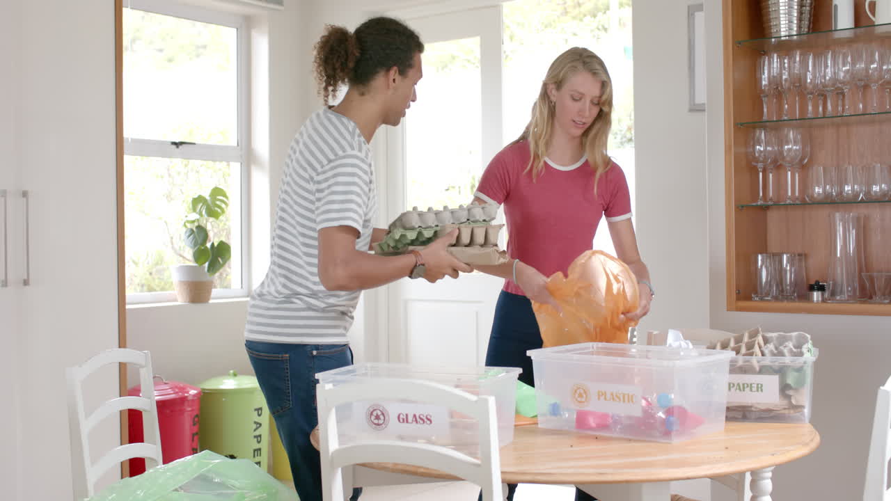 다양한 행복한 커플이 집에서 쓰레기를 분리하고 이야기하고, 느린 동작