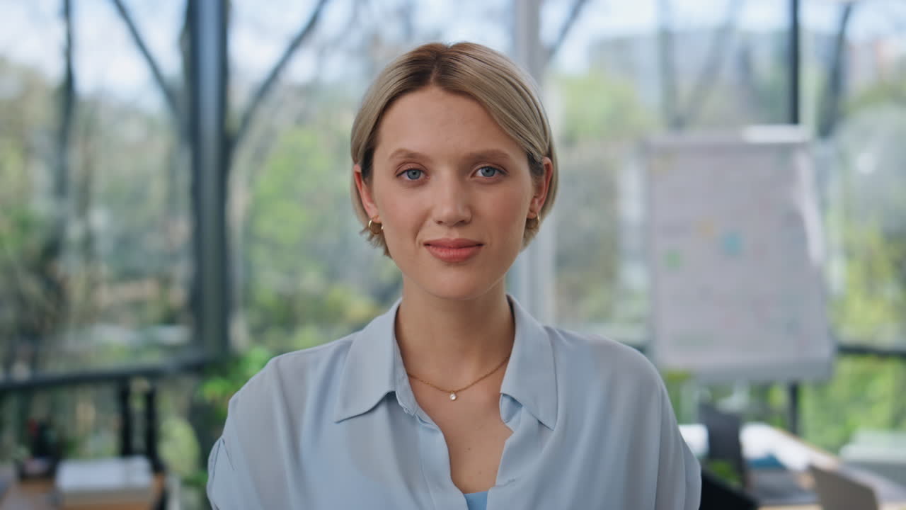 retrato del gerente satisfecho posando en la oficina con efecto borroso. mujer mirando la cámara