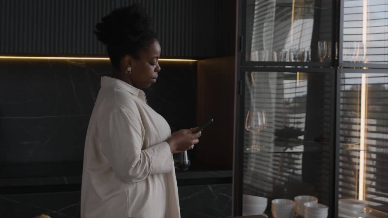 A woman using her phone by the window