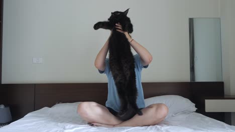 Maine-Coon-cat-being-held-high-and-swayed-by-young-adult-female,-slow-mo