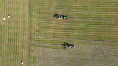 top view drone shot of two tractors working with hay in rhenen in the netherlands