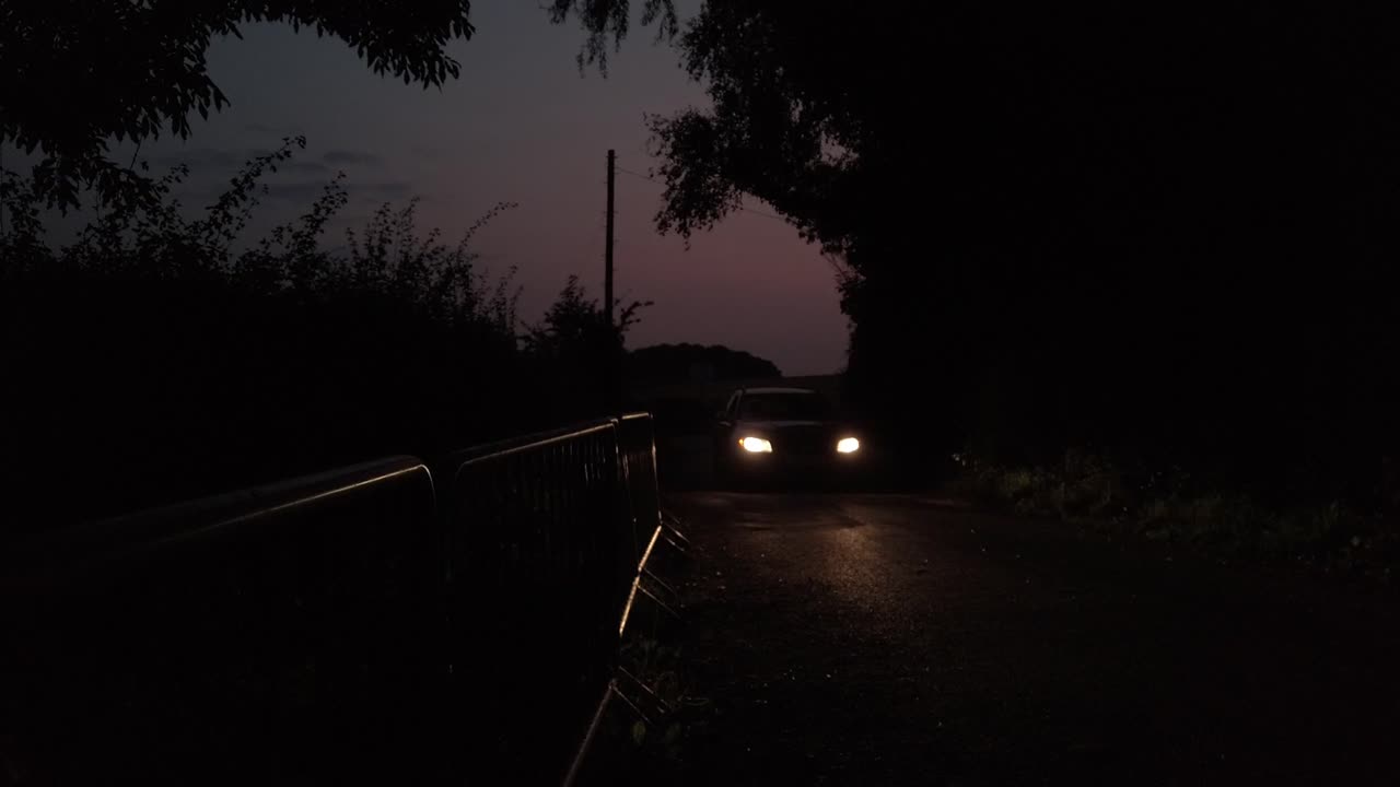 Car driving toward with head lamps on at night