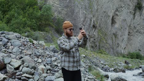 man taking pictures in a mountain canyon