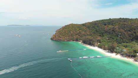 speed boat leaving to thailand main land from banana beach bay in koh hey - aerial wide high panoramic shot