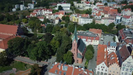 Imágenes-De-Drones-Del-Casco-Antiguo-De-Olsztyn,-Polonia,-Con-Una-Antigua-Iglesia-Evangélica-Y-Un-Castillo-Al-Fondo