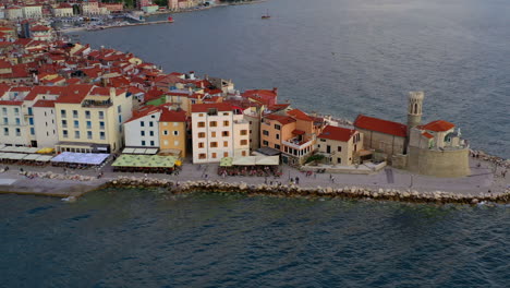 aerial shot of piran lighthouse and the amazing town at golden hour, slovenia