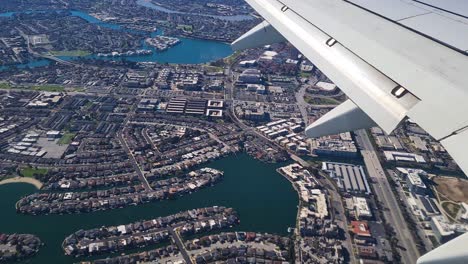 airplane flying above foster city in san francisco bay, california usa, plane passenger pov over wing