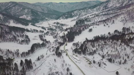 carretera verde serpenteante a lo largo del fondo del valle de las tierras altas en invierno