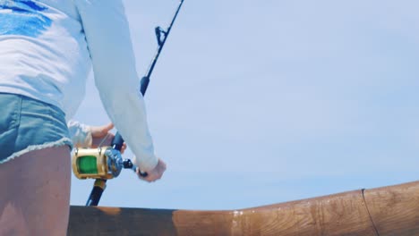 Girl-reeling-in-a-fish-in-the-blue-Caribbean-Sea