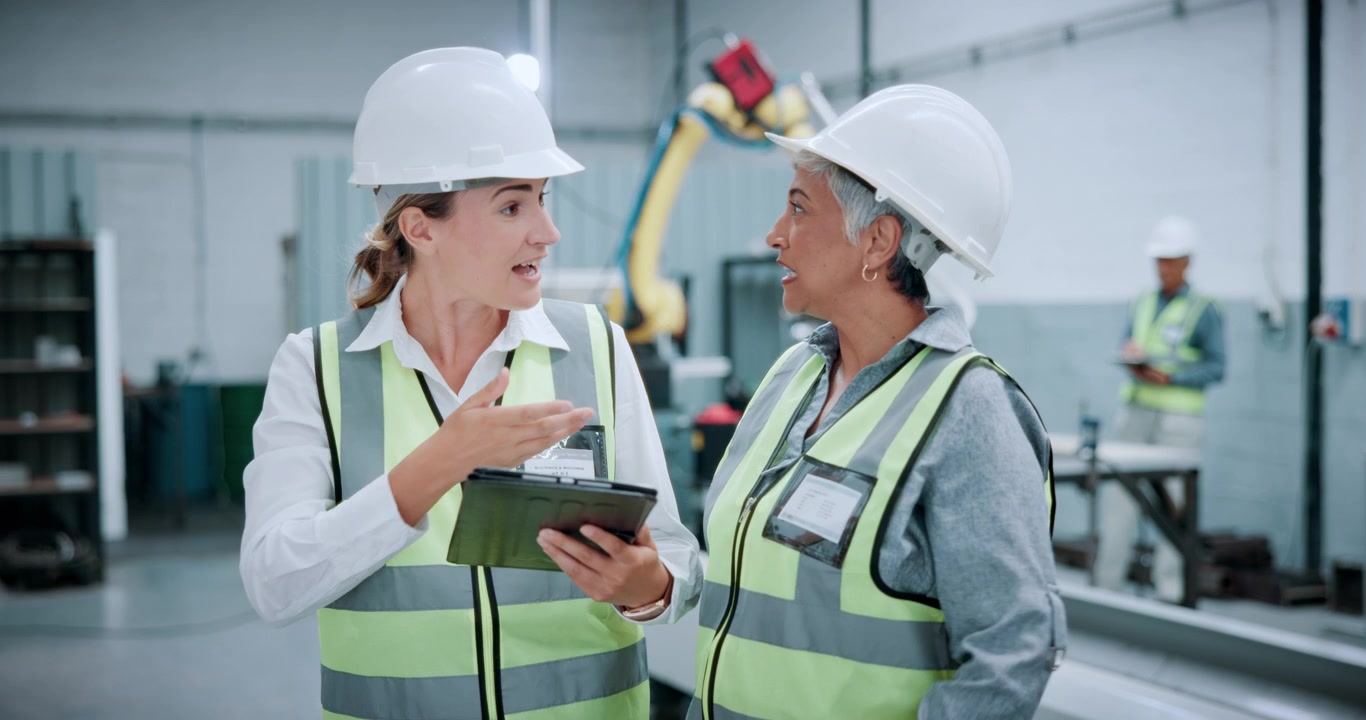 Two Female Engineers Discussing Project in Industrial Factory