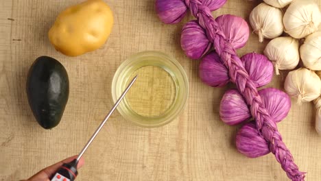 checking oil temperature for cooking with vegetables and garlic