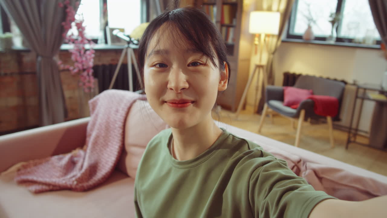 젊은 아시아 여성은 집에서 웹 통화에 대해 이야기합니다.