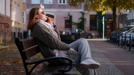 woman talking on phone in city park