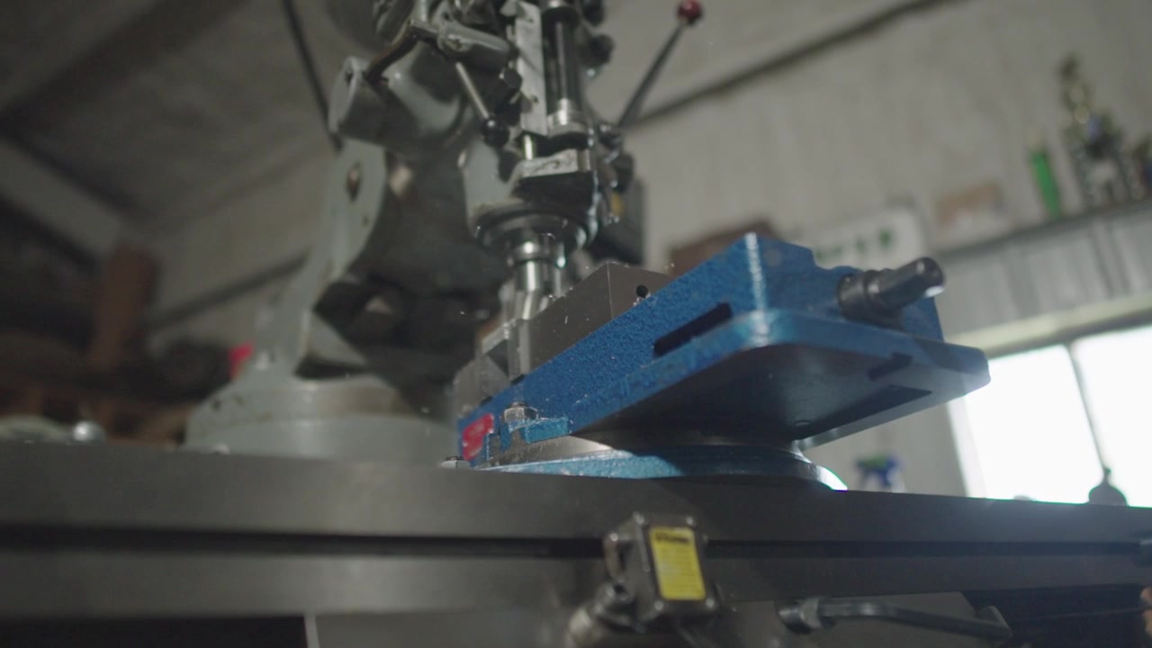 Un primo piano al rallentatore di una macchina Bridgeport che asporta metallo e lo fa volare verso la telecamera con un movimento cinematografico
