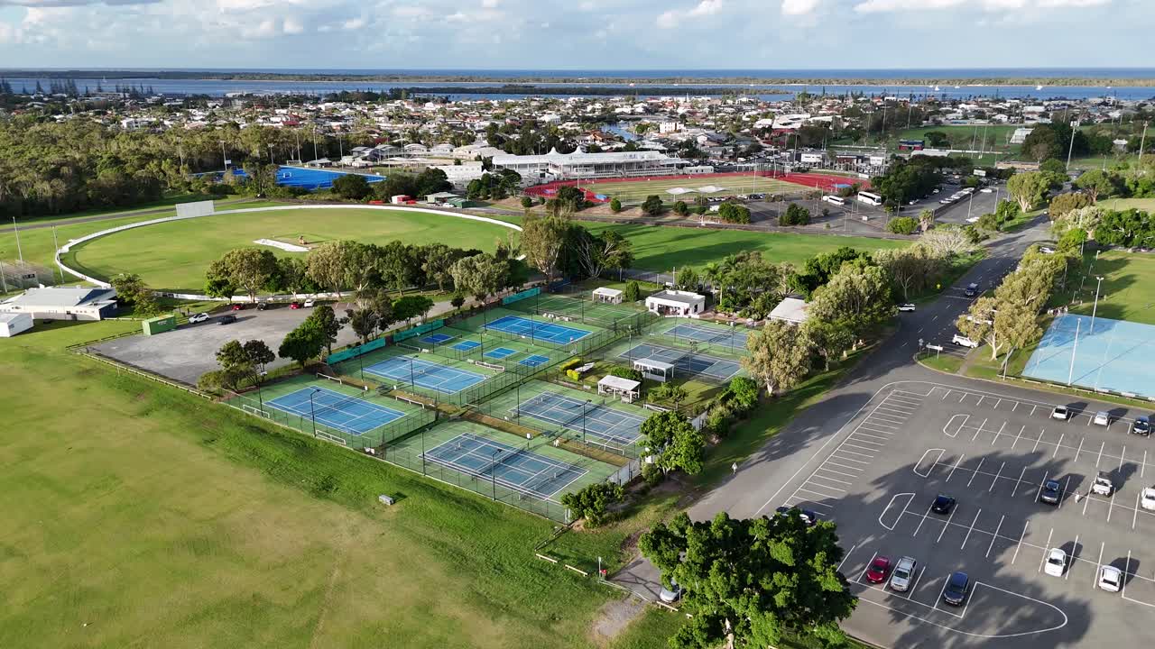 Drone footage captures sports facilities and parking area under clear skies at Gold Coast, Australia