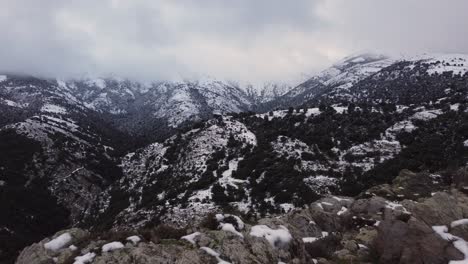 Epische-Luftaufnahme-Der-Schneebedeckten-Berglandschaft,-Bewölkter-Gipfel,-Luftaufnahme