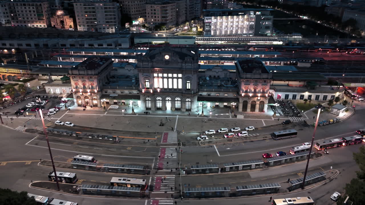 Arcing aerial night view of lit up Brignole railway station in Genoa, Italy