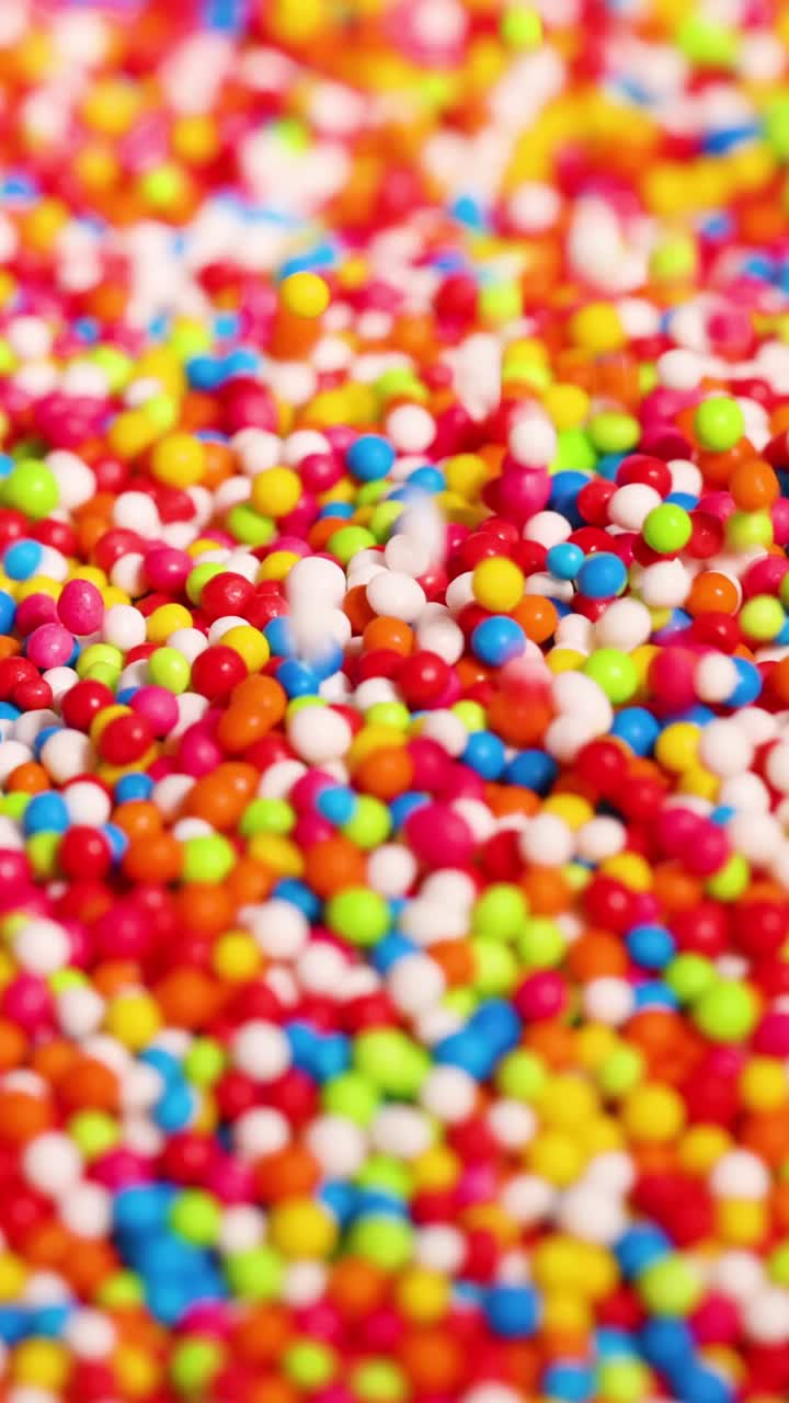 Mani che giocano con zuccherini colorati e vivaci