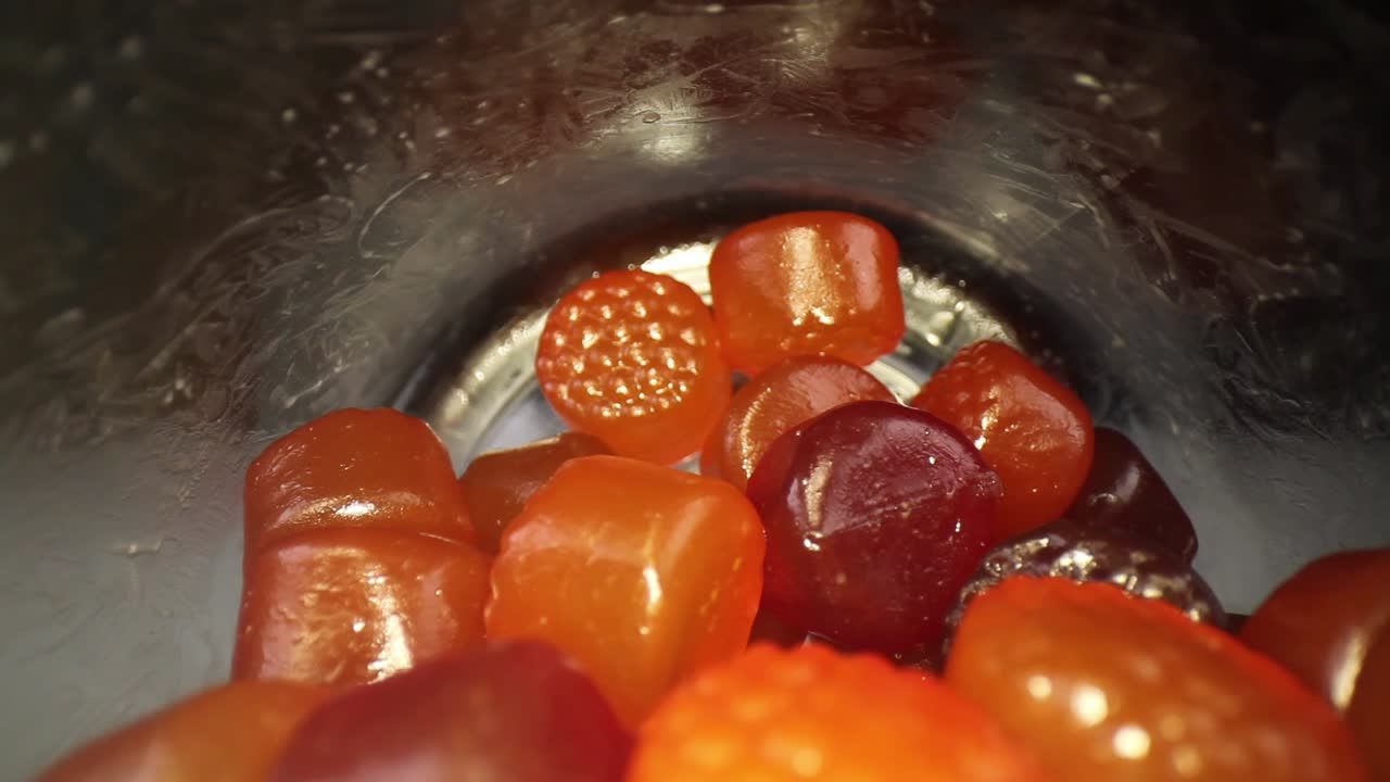 sacando lentamente de una botella de multivitaminas para adultos viajando casi toda la longitud de la botella