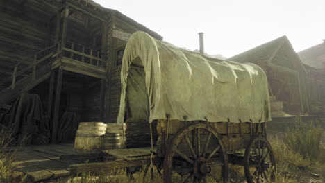 old wooden wagon in a rustic settlement surrounded by buildings and barrels