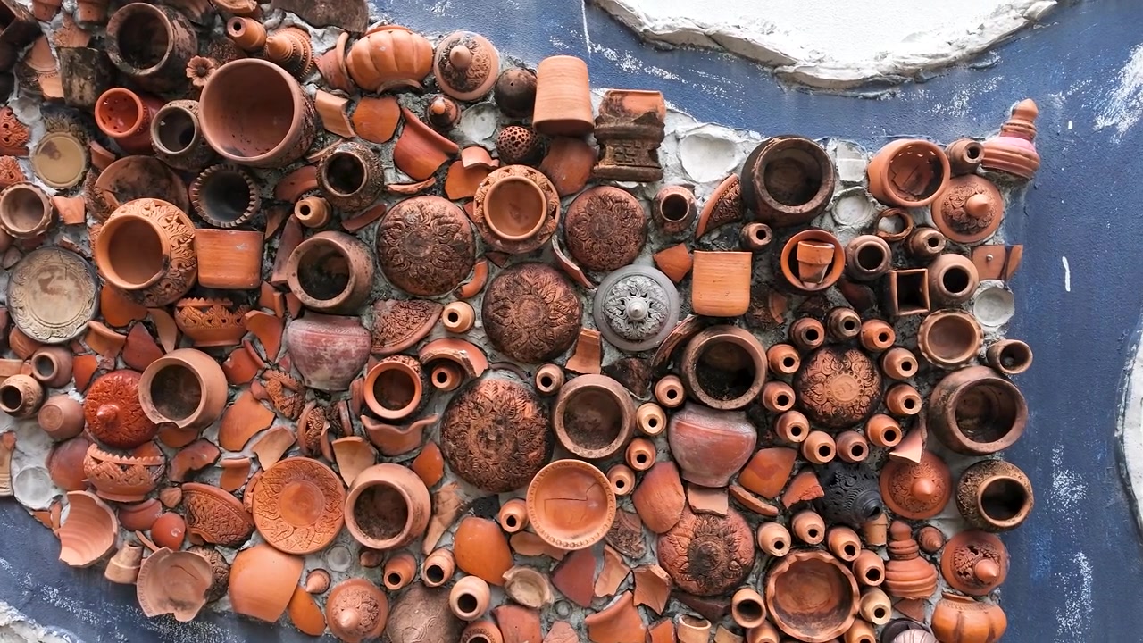 Primo piano di un'intricata arte murale a mosaico in ceramica di terracotta a Koh Kret, Nonthaburi, Thailandia.