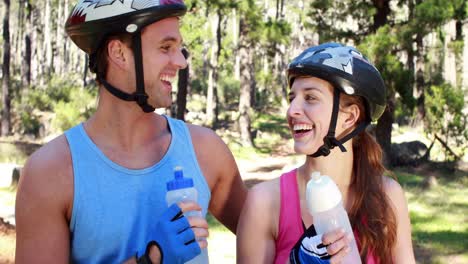 pareja con bicicletas bebiendo agua