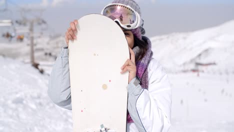 Lachende-Junge-Frau-Mit-Ihrem-Snowboard