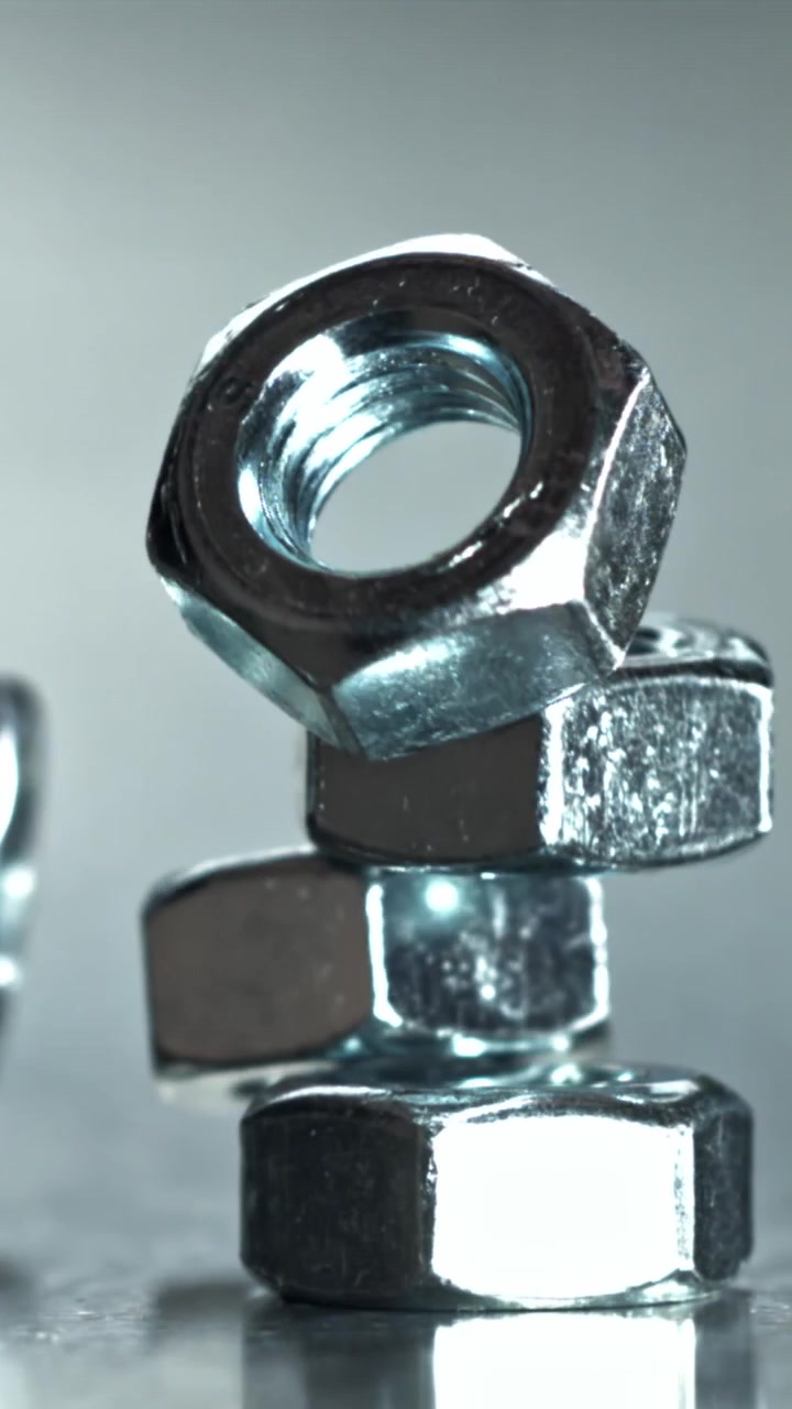 Primo piano al rallentatore di dadi metallici che si impilano