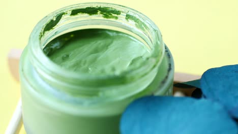 green clay face mask in a jar