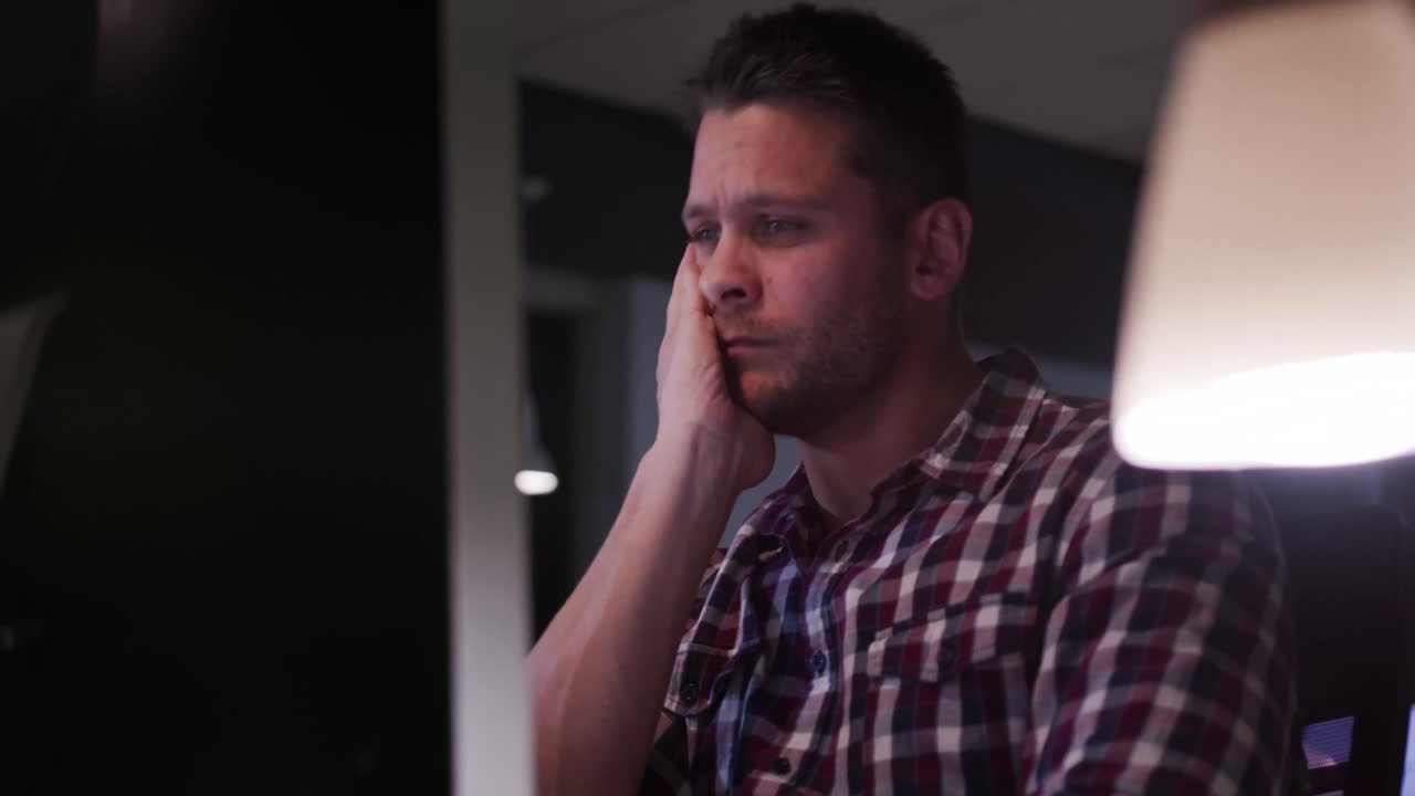 hombre de negocios cansado trabajando en una oficina moderna por la noche