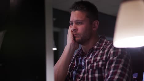 hombre de negocios cansado trabajando en una oficina moderna por la noche
