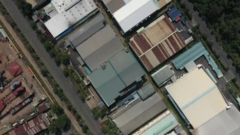rotación en el sentido de las agujas del reloj y vuelo con vista de arriba hacia abajo sobre grandes edificios industriales con carreteras, parques y canales