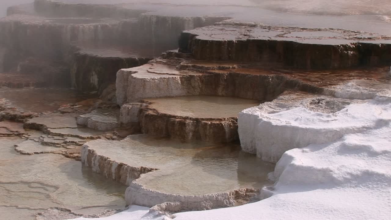 증기 눈과 열 풀이 있는 온천 석회암 테라스의 화려한 근접 촬영 모습