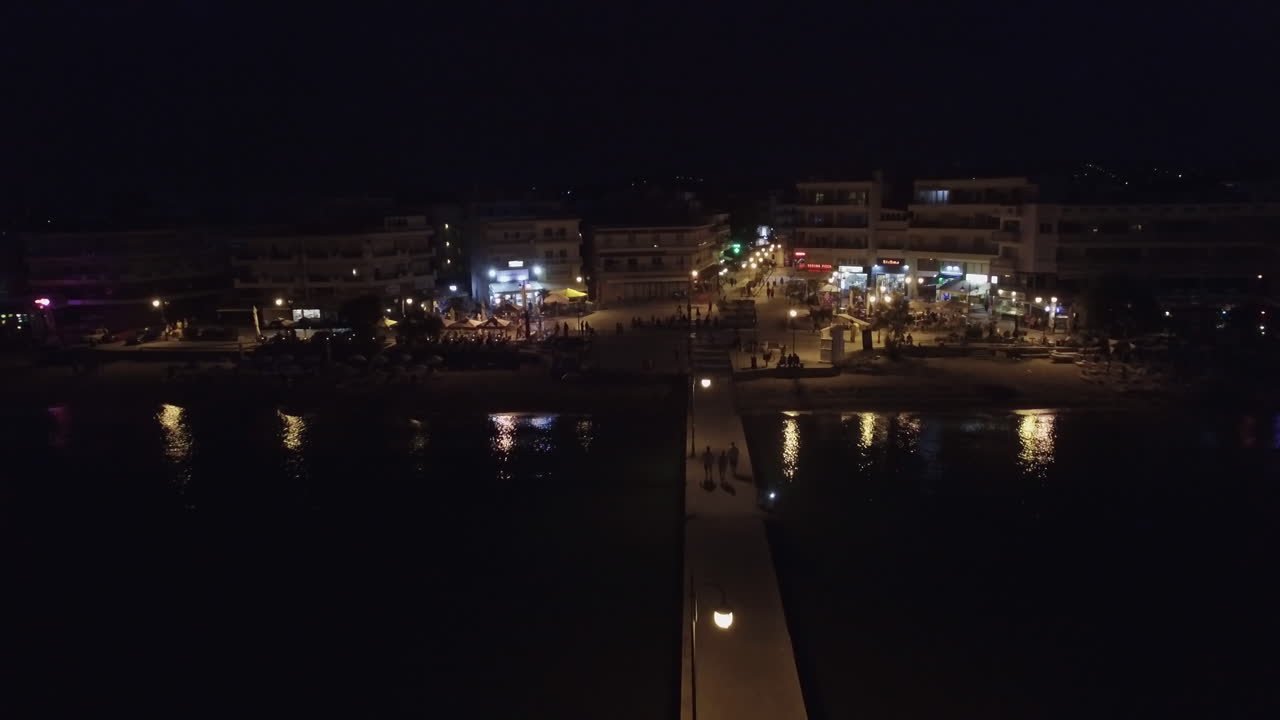 воздушный полет над морем, уходящий от береговой линии с курортным районом в греции