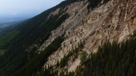 Aerial-view-tilting-toward-a-rocky-landslide-area-in-the-mountains-of-BC,-Canada