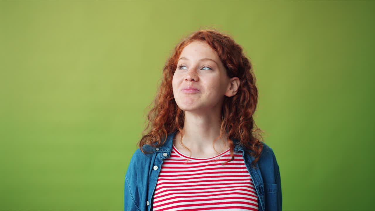 Woman with red curly hair sending a kiss